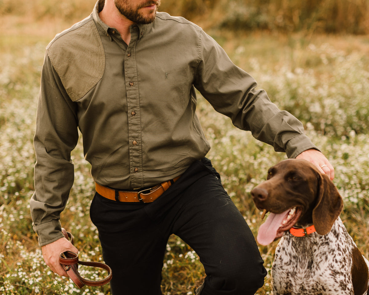 Man kneeling with a pointing dog wearing the Ranger Green Jack Carr Hunters Shirt