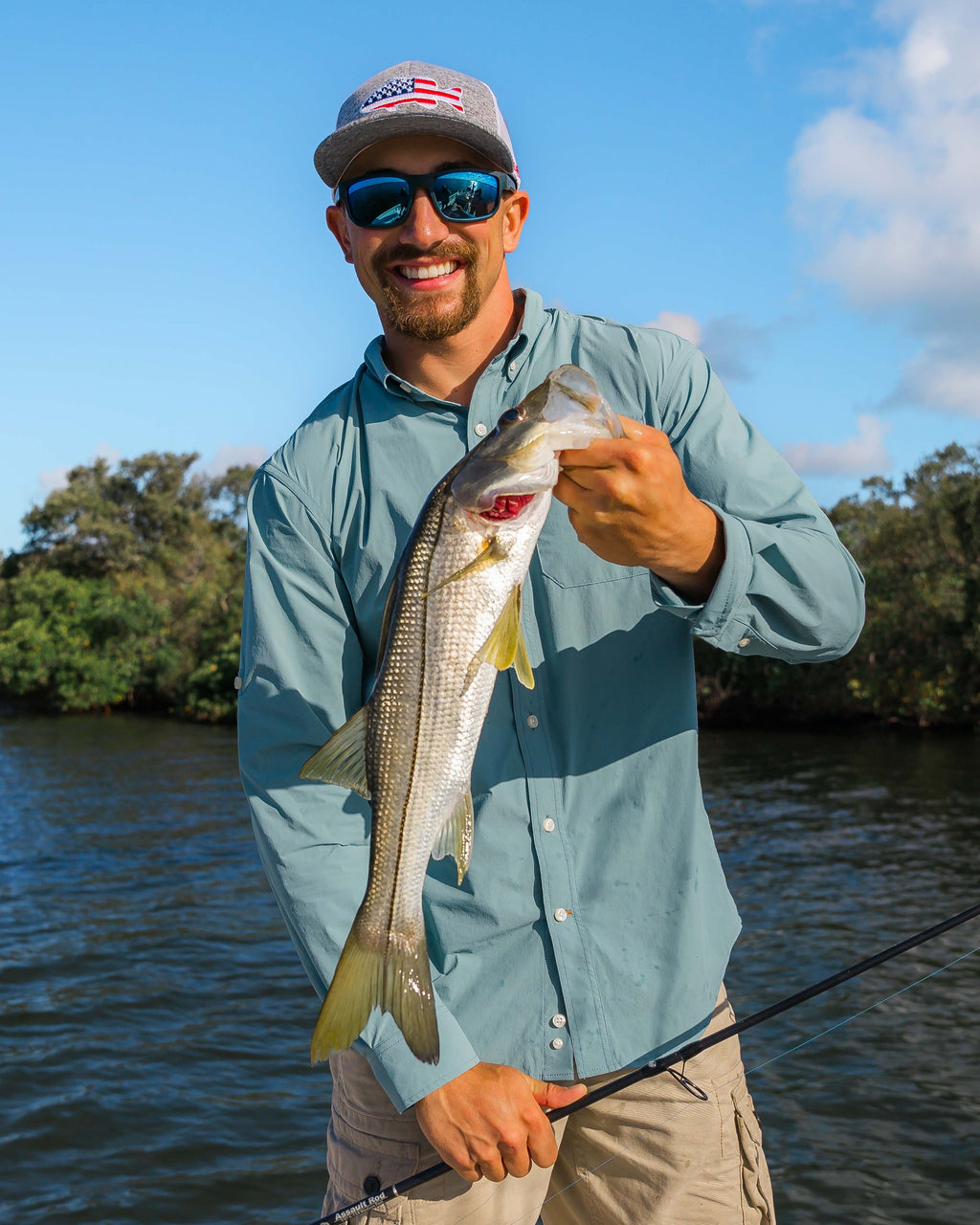 Angler holding a speckled trout in the River Green Active+ Guide Shirt