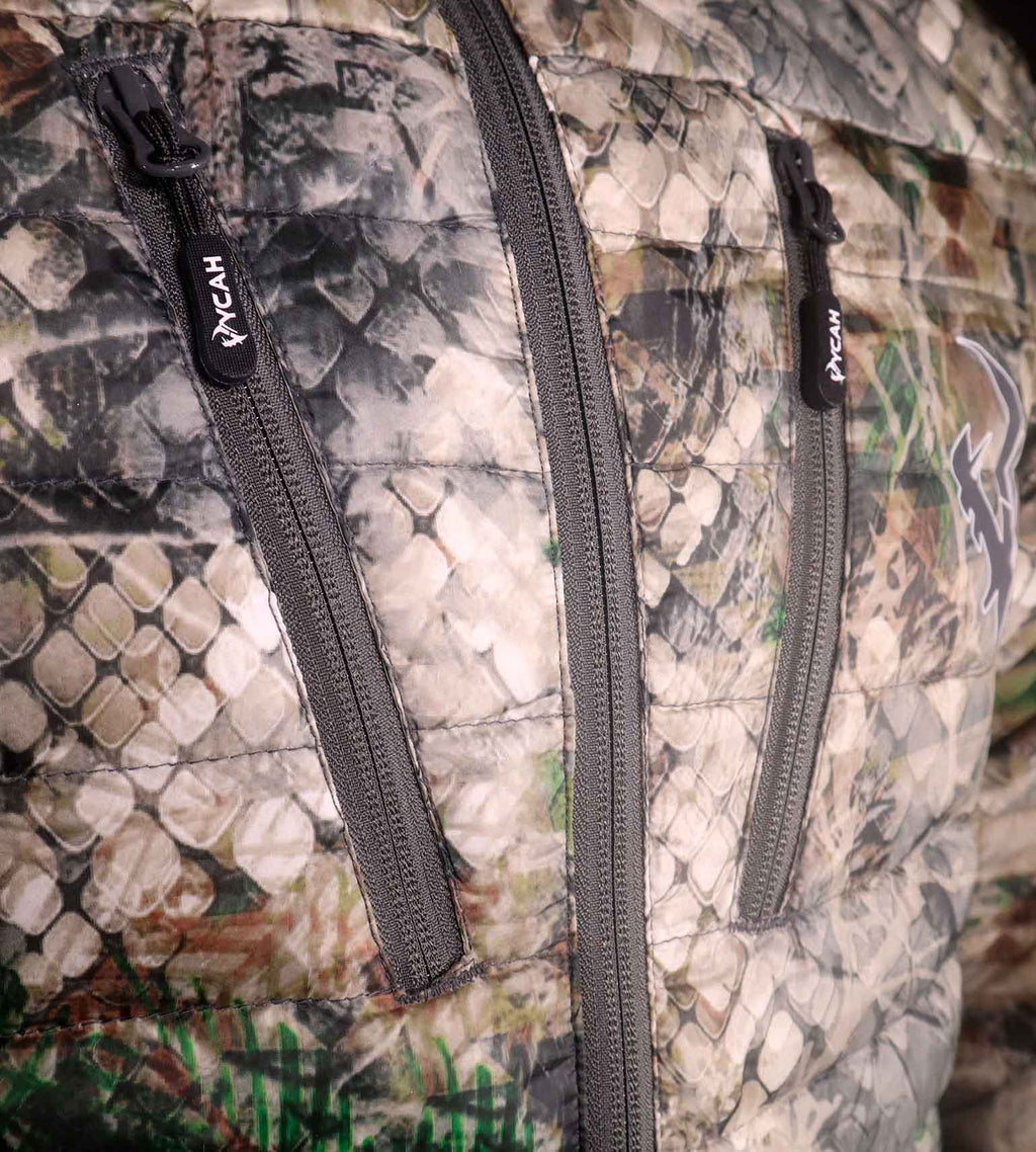 Close-up of the two zippered chest pockets and Vycah zipper pulls on the Cobalt Down Jacket in Fall camo