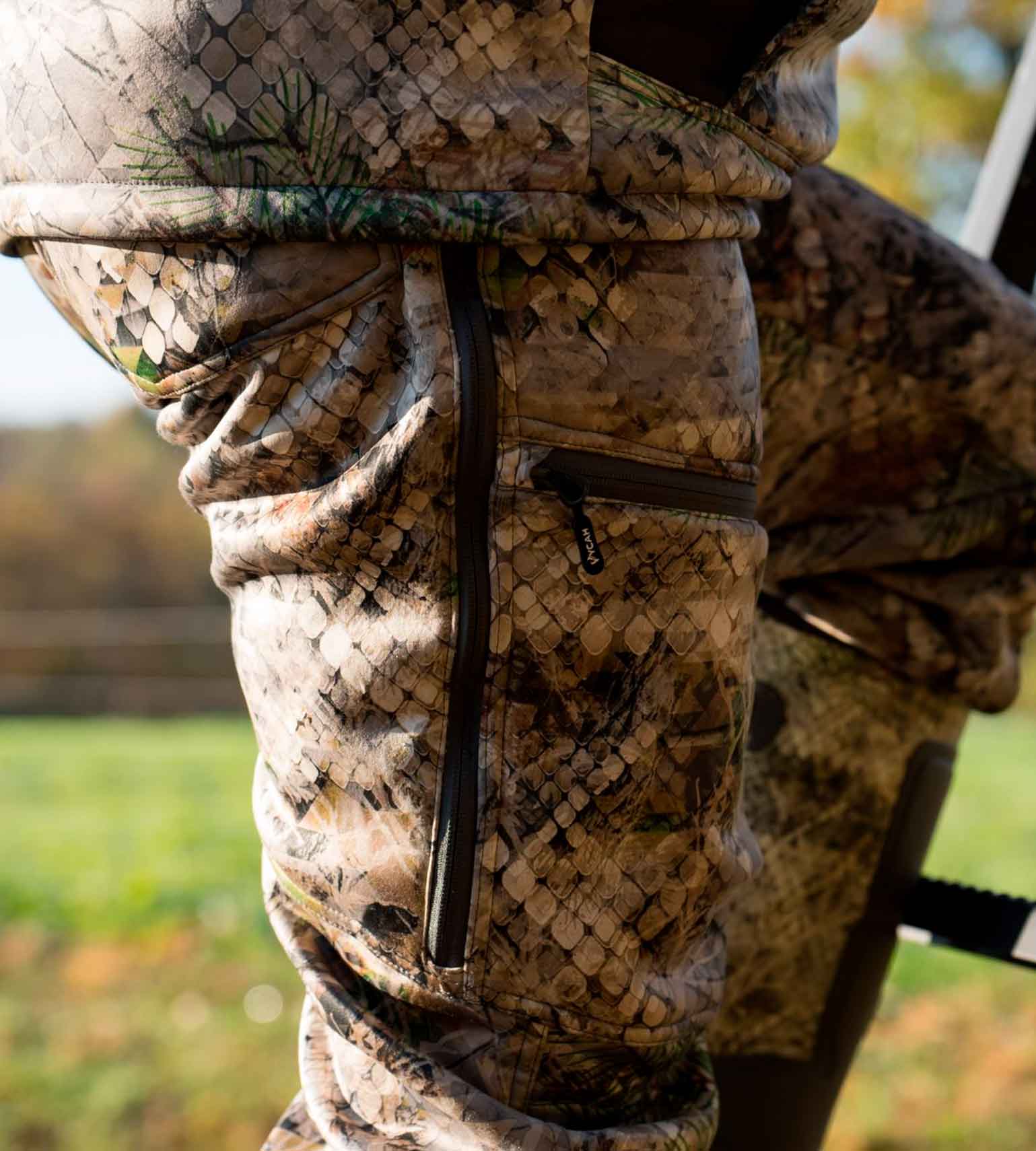 Close-up of the zippered thigh pocket on Vycah Kinsley Pants in Fall camo
