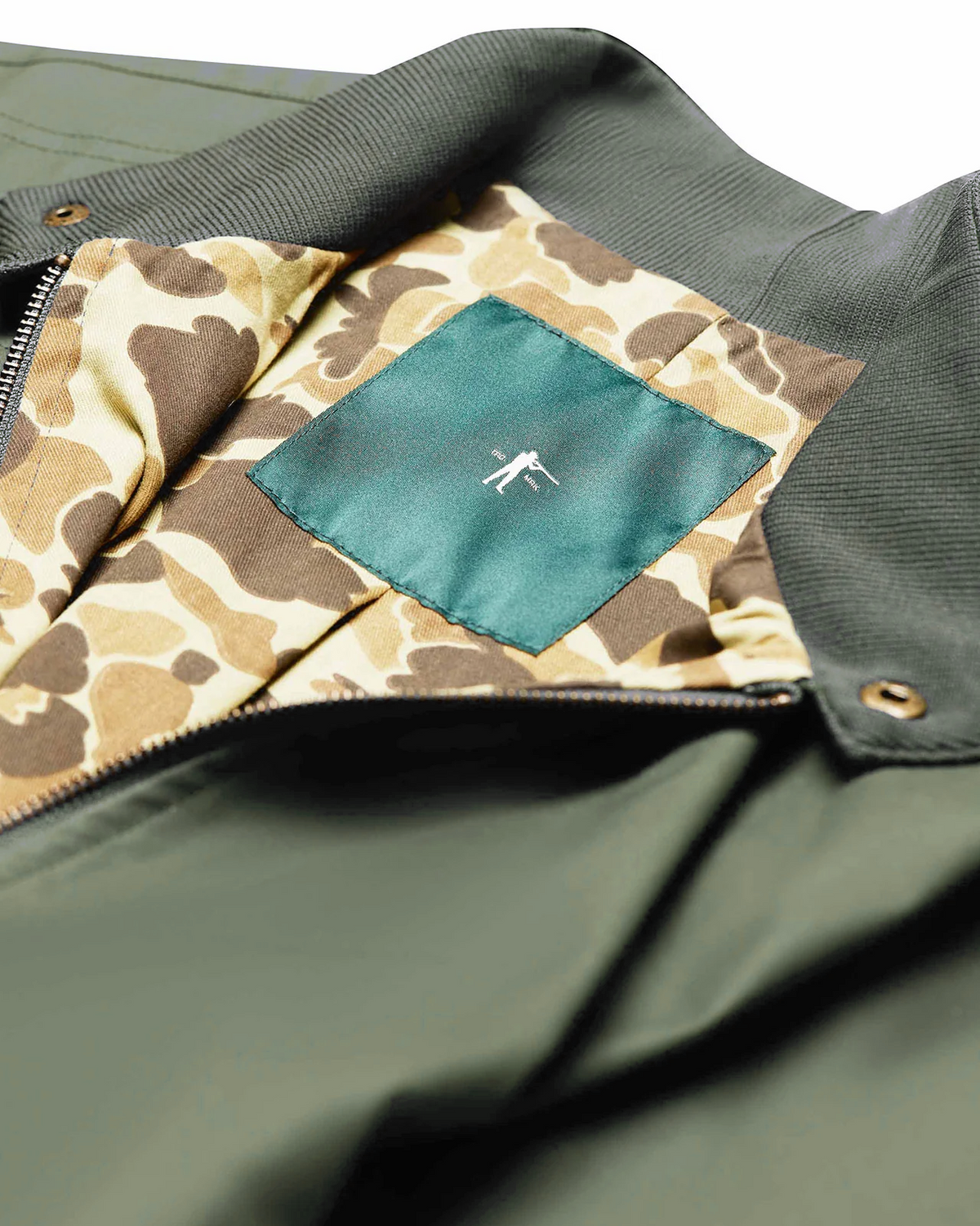 Camo lining and green inner label of the Sage Green Harrington Jacket
