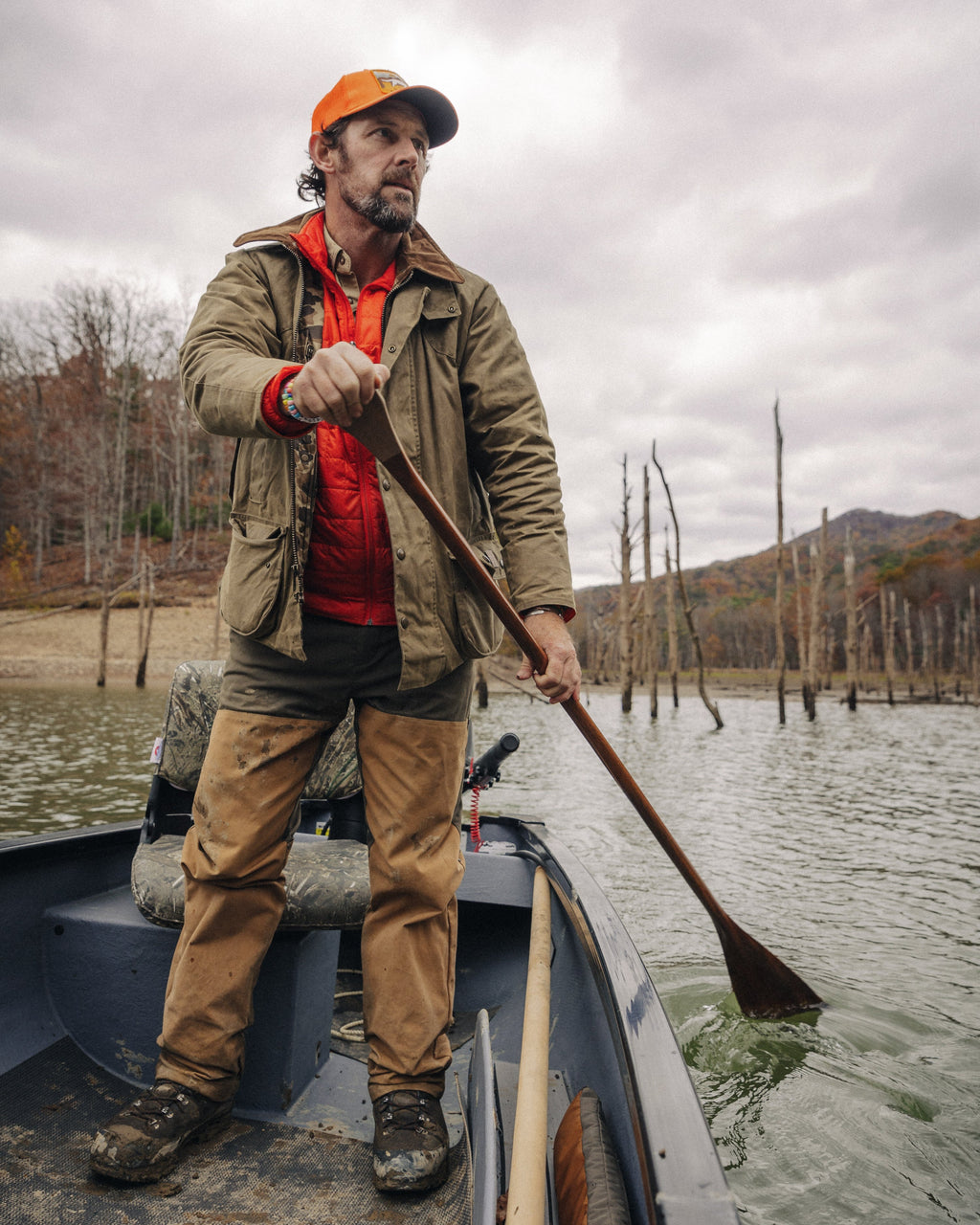 Hunter poling a boat on flooded timber wearing the Upland Jacket