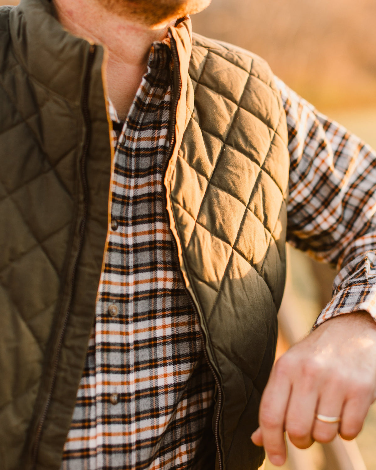 Loden Arthur Down Vest worn over a plaid shirt, close-up of the gradient shoulder quilting