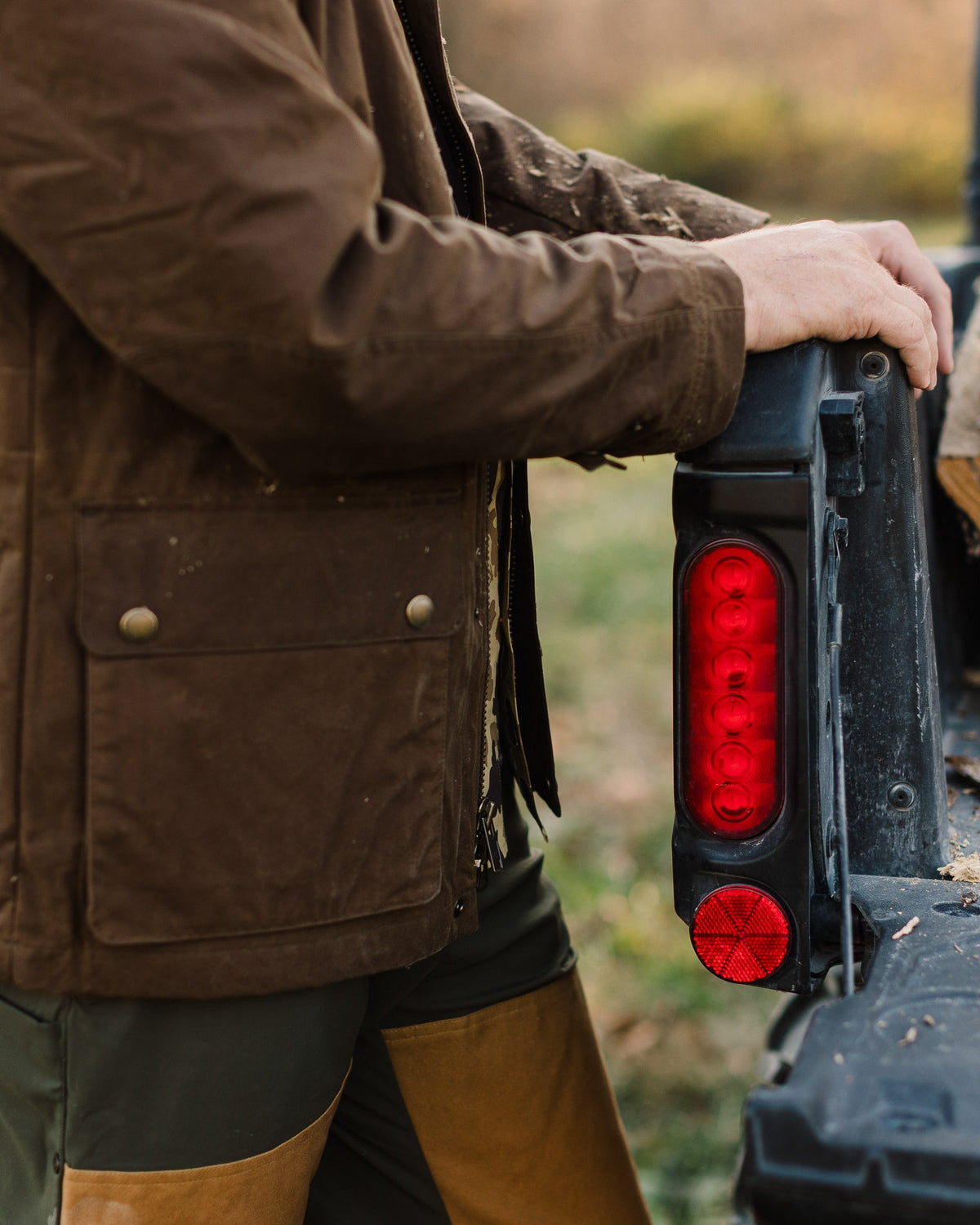 Side view of the Oak Waxed Field Jacket worn while working at a UTV