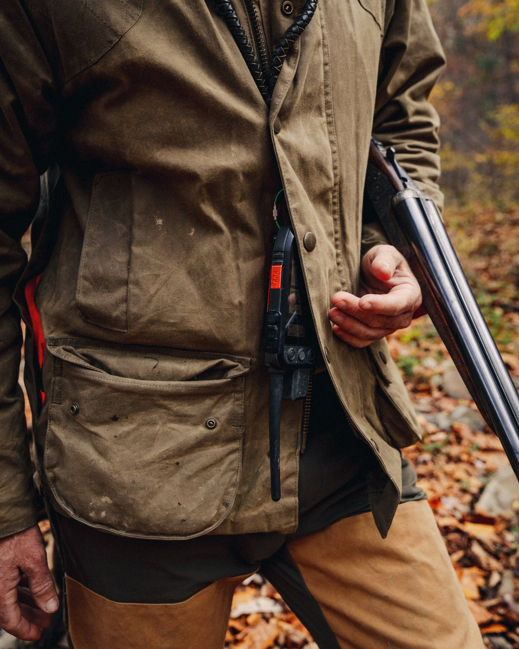 Olive Upland Jacket worn while carrying a shotgun, front close-up